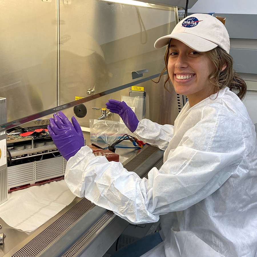 Fourth-year biomedical engineering student and Space Tango intern Nicole Frey at a lab hood with the CubeLab scheduled to fly to the International Space Station July 14 aboard a SpaceX Dragon capsule. (Photo Courtsey: Nicole Frey and Space Tango)