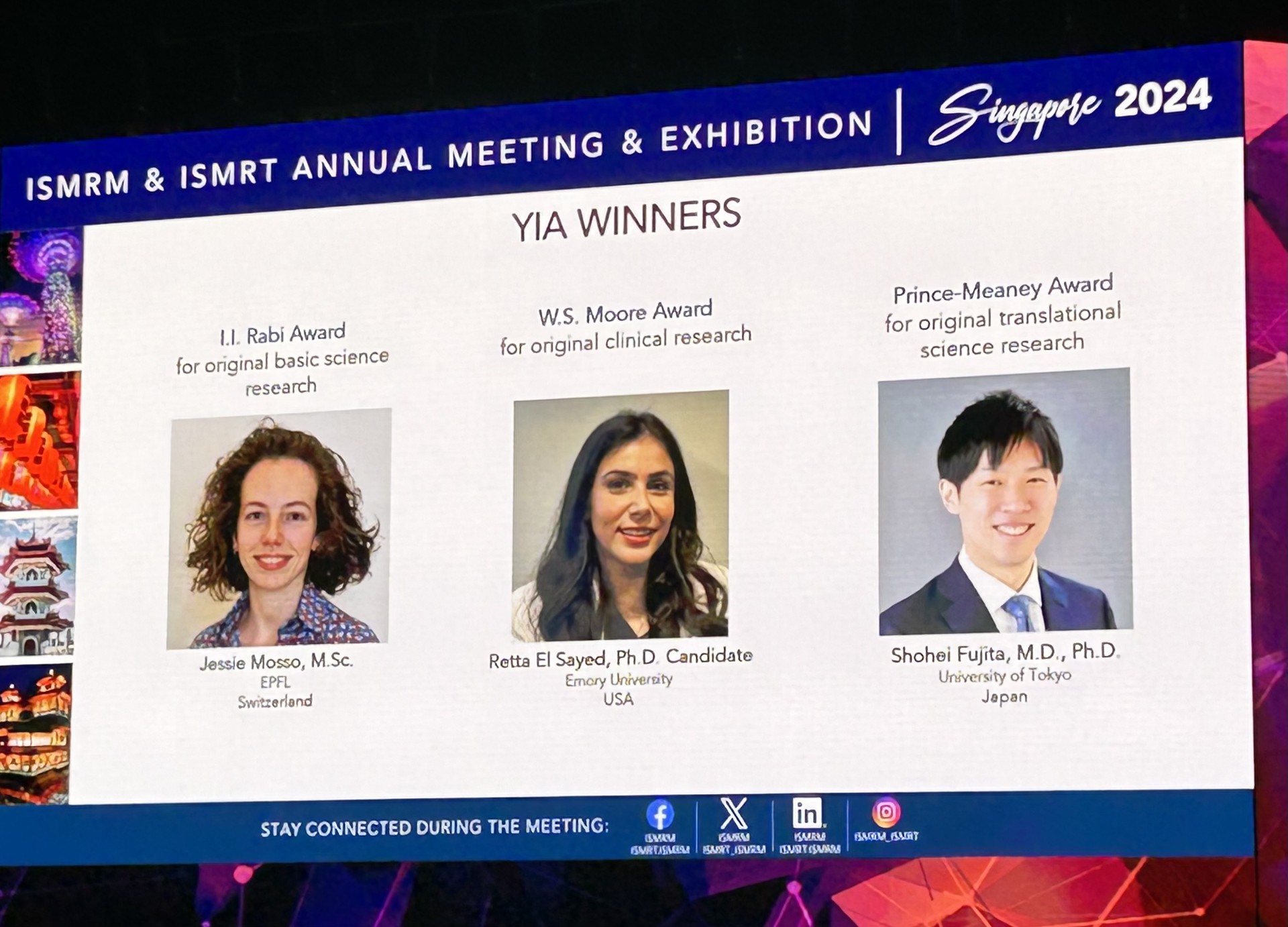 Photo of a large projection screen featuring the winners of the Young Investigators Award. Retta El Sayed's photo is in the middle flanked by another female student photo on the left and a male student photo on the right.