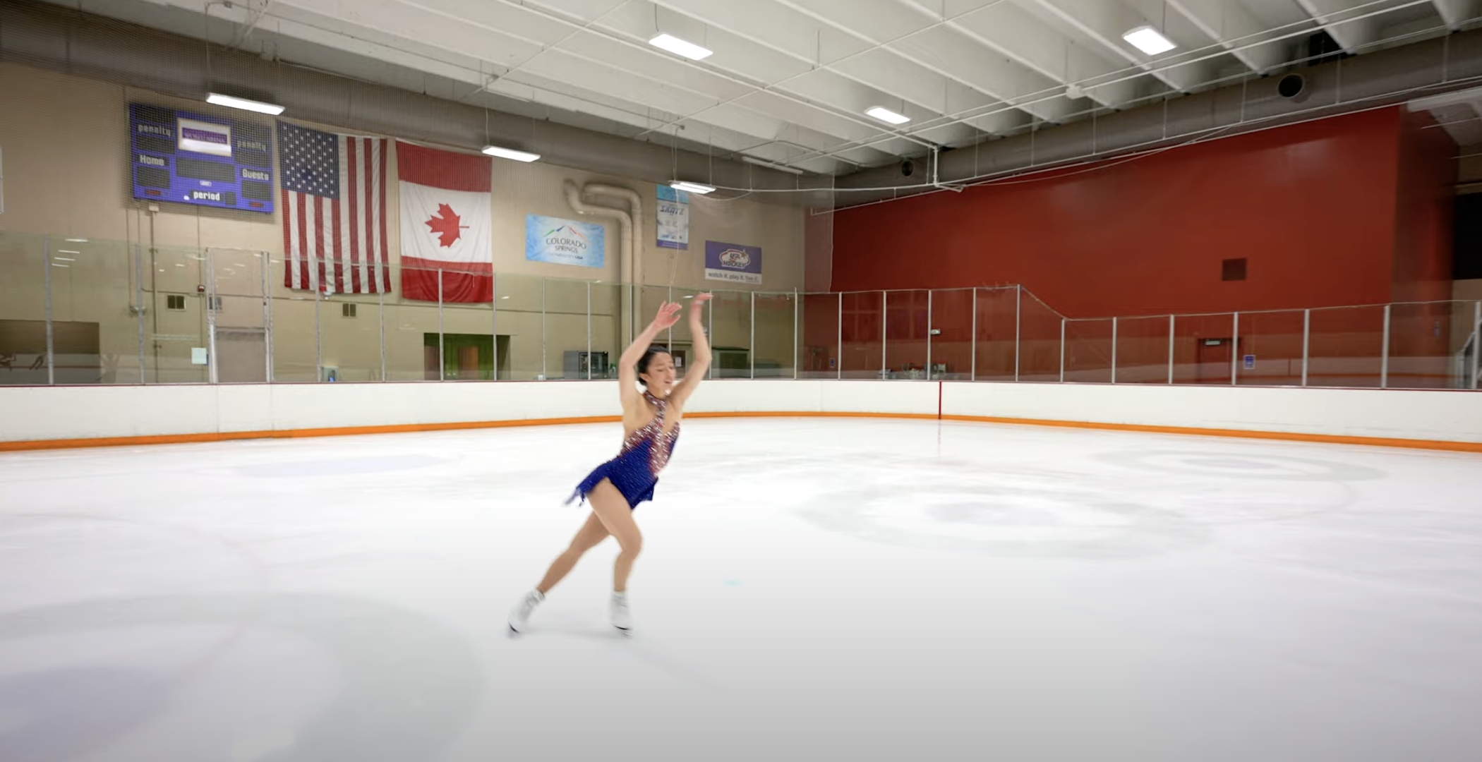 Photo of Sierra Venetta in a dark blue figure skating costume practicing skating on the ice