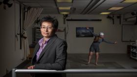 Photo of Professor Lena Ting in the foreground with a research subject in the background 