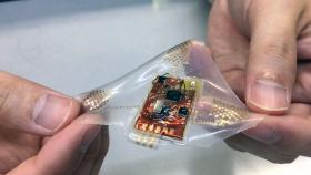 A wireless, wearable monitor built with stretchable electronics could allow comfortable, long-term health monitoring of adults, babies and small children. (Photo: John Toon, Georgia Tech)