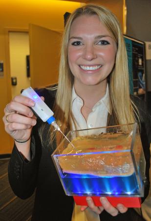 Marci Medford demonstrates the device her Capstone team developed.