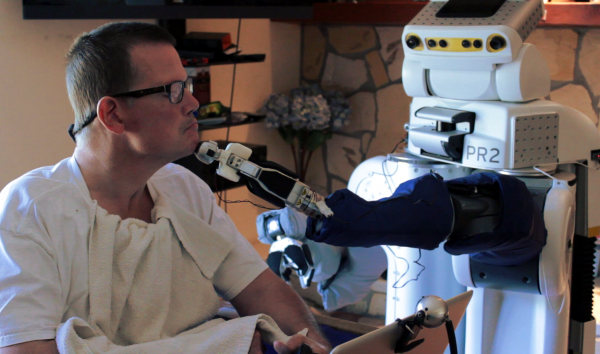 Robotic body surrogates can help people with profound motor deficits interact with the world. Here, Henry Evans, a California man who helped Georgia Tech researchers with improvements to a web-based interface, uses the robot to shave himself. (Credit: Henry Clever/Phillip Grice, Georgia Tech)