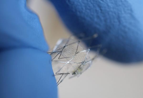 With gloved fingers for scale, a proof-of-concept flow sensor is shown here on a stent backbone. (Credit: Woon-Hong Yeo, Georgia Tech)