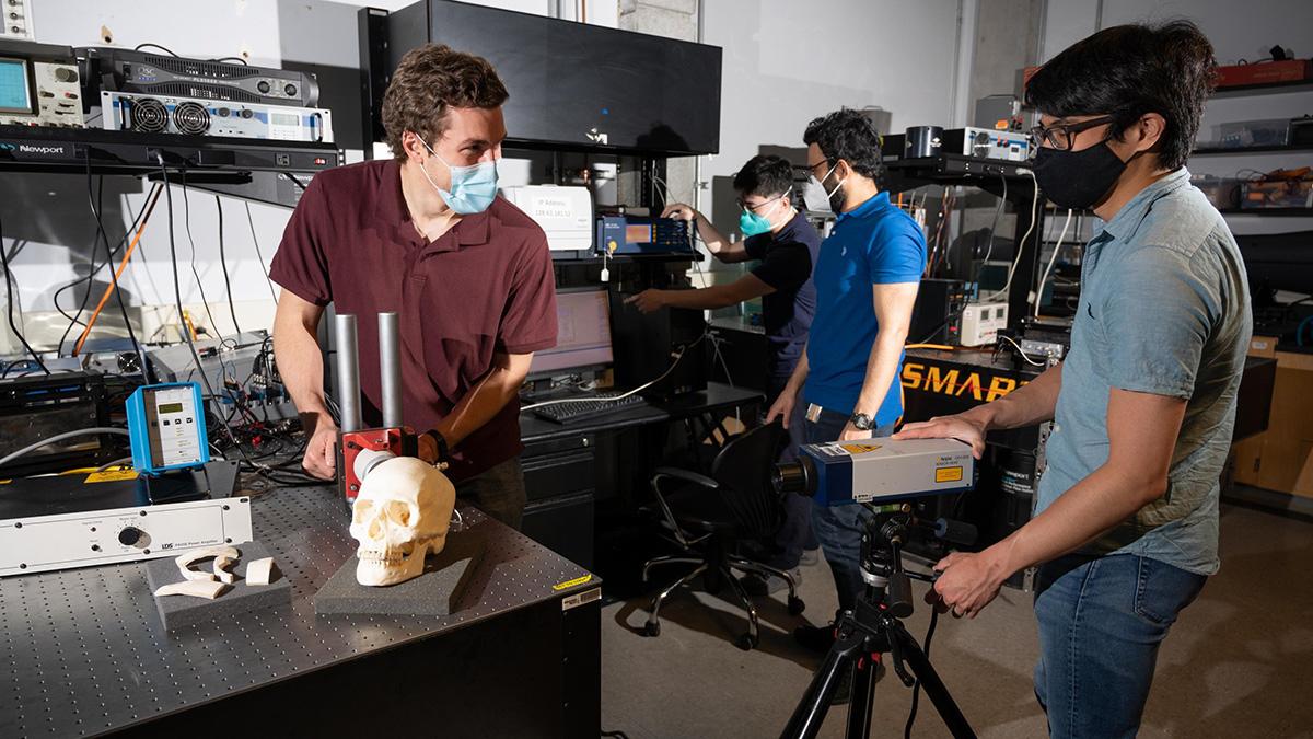 Graduate research assistants Eetu Kohtanen and Pradosh Dash and postdoctoral researchers Christopher Sugino and Bowen Jing test a human skull to measure and characterize its vibration response. (Photo: Allison Carter, Georgia Tech)