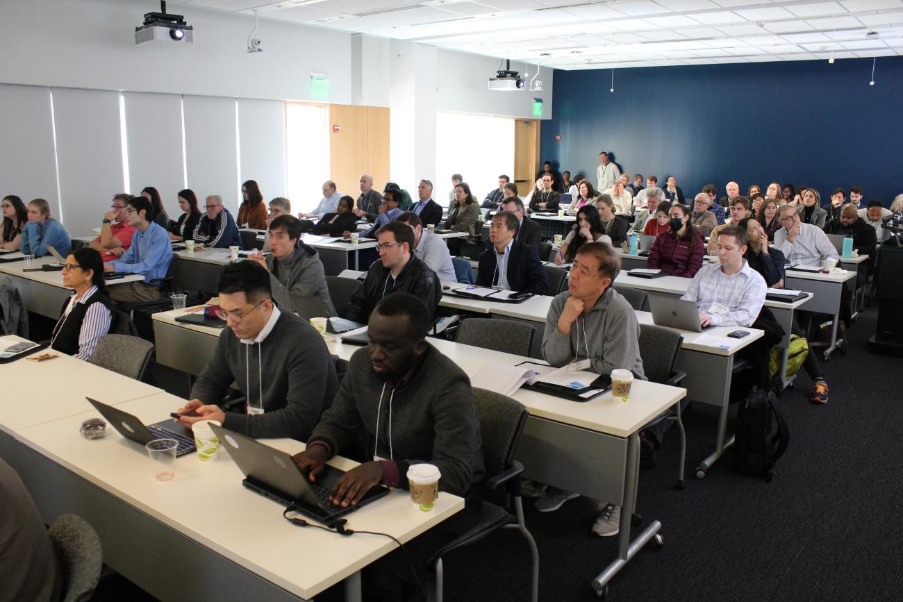 Photo of a room full of female and male researchers looking ahead at a presenter.